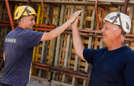 Polier und Facharbeiter geben sich ein High-Five